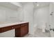 Bright bathroom featuring a large mirror, wood vanity, tiled floors, and shower at 9198 Harbin Ave, Las Vegas, NV 89148