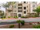 Beautiful condo building featuring manicured landscaping and mature palm trees at 9201 Tesoras Dr # 302, Las Vegas, NV 89144