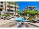 Community hot tub with lounge chairs surrounded by palm trees and buildings at 9201 Tesoras Dr # 302, Las Vegas, NV 89144