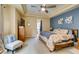 Main bedroom with carpet flooring, a tray ceiling, blue accent wall, and natural lighting at 9201 Tesoras Dr # 302, Las Vegas, NV 89144