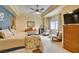 Spacious main bedroom featuring tray ceilings, ceiling fan, sitting area, and carpeted floors at 9201 Tesoras Dr # 302, Las Vegas, NV 89144