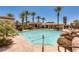 Community pool surrounded by palm trees and lounge chairs at 9201 Tesoras Dr # 302, Las Vegas, NV 89144