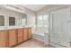 Well-lit primary bath featuring double sinks, shower and tub at 9537 Michelle Falls Ave, Las Vegas, NV 89149