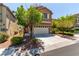 Charming two-story home with a two-car garage and driveway framed by mature shade trees and rock landscaping at 9537 Michelle Falls Ave, Las Vegas, NV 89149