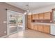 Bright kitchen with tile floors, oak cabinets, and sliding door leading to a brick patio at 9537 Michelle Falls Ave, Las Vegas, NV 89149