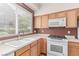 This kitchen features oak cabinets, white appliances and a large window at 9537 Michelle Falls Ave, Las Vegas, NV 89149