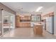 Bright eat-in kitchen featuring a functional island, tile floors and sliding doors to the patio at 9537 Michelle Falls Ave, Las Vegas, NV 89149