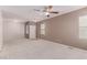 Large open living room with neutral colored walls, carpet, ceiling fan, and natural light at 9537 Michelle Falls Ave, Las Vegas, NV 89149