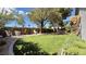 Lush backyard featuring mature trees, manicured lawn, and multiple seating areas for relaxation and enjoyment at 988 Upper Meadows Pl, Henderson, NV 89052