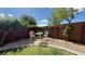 Private backyard nook with decorative seating, rock landscaping, and mature trees at 988 Upper Meadows Pl, Henderson, NV 89052