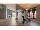 Open-concept dining area with modern chandelier, tile floors, and views of the living room at 988 Upper Meadows Pl, Henderson, NV 89052