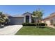Charming single-story home with a well-manicured lawn, mature landscaping, and a gray exterior at 988 Upper Meadows Pl, Henderson, NV 89052
