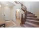 Inviting entryway featuring a curved staircase, tiled flooring with decorative border, and access to other rooms at 1 Cerchio Basso, Henderson, NV 89011