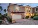 Charming home featuring a two-car garage, desert landscaping, and a cozy front porch at 1 Cerchio Basso, Henderson, NV 89011
