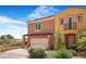 Charming townhome featuring stucco siding, an attached two-car garage, and well-manicured landscaping at 1 Cerchio Basso, Henderson, NV 89011