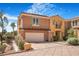 Charming townhome featuring stucco siding, an attached two-car garage, and well-manicured landscaping at 1 Cerchio Basso, Henderson, NV 89011