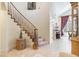 Elegant foyer with high ceilings, tile flooring, and a beautiful wooden staircase at 1 Cerchio Basso, Henderson, NV 89011