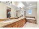 Bathroom featuring double sinks with granite countertops and an oversized soaking tub at 1 Cerchio Basso, Henderson, NV 89011