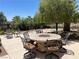 Outdoor patio featuring an elegant round dining table, seating for six, and lush landscaping at 1 Cerchio Basso, Henderson, NV 89011