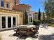 View of the outdoor patio area, featuring a round table, outdoor seating, and manicured landscaping at 1 Cerchio Basso, Henderson, NV 89011