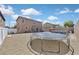 Large backyard with gravel, trampoline, above-ground pool, and covered patio, perfect for outdoor activities at 1020 High Altitude Ave, North Las Vegas, NV 89032