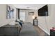 Comfortable living room area with a plush sofa, mounted TV, and a mini-fridge, perfect for relaxation and entertainment at 1020 High Altitude Ave, North Las Vegas, NV 89032