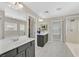 Bright main bathroom featuring double sinks, a walk-in shower, and a separate soaking tub at 1020 High Altitude Ave, North Las Vegas, NV 89032