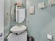 Charming powder room featuring a white vanity, round mirror, and decorative wall art at 1020 High Altitude Ave, North Las Vegas, NV 89032
