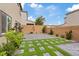 Back exterior showcasing grass squares and a large paved patio area with block wall at 10324 Stroma Ave, Las Vegas, NV 89166