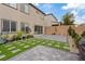 Multi-story back exterior with grass squares, paved patio, and privacy wall at 10324 Stroma Ave, Las Vegas, NV 89166