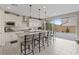 Modern kitchen with white cabinets, island seating, stainless appliances and patio doors at 10324 Stroma Ave, Las Vegas, NV 89166