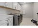 Fully equipped laundry room with modern appliances, counter space, and overhead cabinetry at 10324 Stroma Ave, Las Vegas, NV 89166