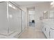 Bright bathroom featuring double sinks and a glass-enclosed shower. A walkway leads to the main bedroom at 10324 Stroma Ave, Las Vegas, NV 89166