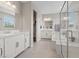 Bright bathroom featuring double sinks, a separate soaking tub, and a glass-enclosed shower at 10324 Stroma Ave, Las Vegas, NV 89166