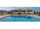 Community pool with lounge chairs, a clubhouse, and mountain views in the background at 10324 Stroma Ave, Las Vegas, NV 89166