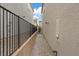 Narrow side yard with pavers, a black metal fence, and a view of the neighboring houses at 10324 Stroma Ave, Las Vegas, NV 89166