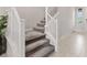 Carpeted stairs with white railing lead to the second story of this open home at 10324 Stroma Ave, Las Vegas, NV 89166