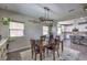 Inviting dining area features a wood table and a stylish light fixture open to the kitchen at 10623 Auburn Springs Ave, Las Vegas, NV 89166