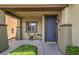 Inviting covered porch with a charming blue front door and manicured landscaping at 10623 Auburn Springs Ave, Las Vegas, NV 89166