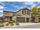Two-story home boasts a multi-car garage and front door with decorative shutters and landscaping at 10623 Auburn Springs Ave, Las Vegas, NV 89166
