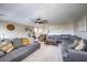 Spacious living room with a large gray sectional sofa, ceiling fan, and neutral decor at 10623 Auburn Springs Ave, Las Vegas, NV 89166