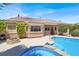 Backyard oasis features a pool, spa, firepit, lush greenery, and a tile roof home at 10805 Hollow Creek Ln, Las Vegas, NV 89144