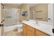 Bright bathroom features a shower over tub with a single vanity sink and wood cabinets at 10805 Hollow Creek Ln, Las Vegas, NV 89144