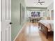 Light-filled bedroom with light green walls, shuttered windows, and wood floors at 10805 Hollow Creek Ln, Las Vegas, NV 89144