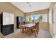 Bright dining area with a view, set for six, with modern refrigerator at 10805 Hollow Creek Ln, Las Vegas, NV 89144