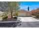Charming single-story home featuring a three car garage and mature landscaping at 10805 Hollow Creek Ln, Las Vegas, NV 89144