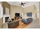 Inviting living room with a ceiling fan, a fireplace, and dark leather couches at 10805 Hollow Creek Ln, Las Vegas, NV 89144