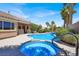 Private backyard with a swimming pool, spa, and tropical landscaping for outdoor enjoyment at 10805 Hollow Creek Ln, Las Vegas, NV 89144