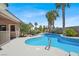 The backyard features a private pool, lush landscape and towering palm trees at 10805 Hollow Creek Ln, Las Vegas, NV 89144