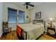 Bedroom with hardwood floors, ceiling fan and a comfortable looking bed near large windows at 11477 Timber Mountain Ave, Las Vegas, NV 89135